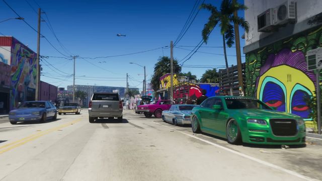 A street scene features several cars, including customized vehicles, parked alongside buildings adorned with…