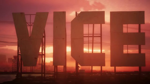 Large letters spelling "VICE" are silhouetted against a vibrant orange and red sunset sky, with a city…