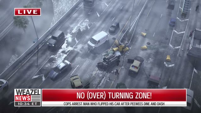 An aerial view shows a multi-lane highway with a flipped car, debris, and several other vehicles, including…