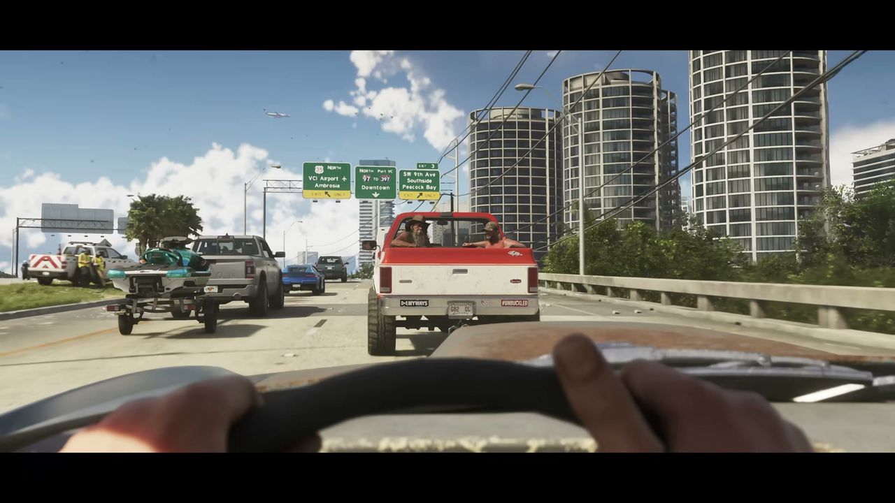 A first-person view from a car shows a multi-lane highway with traffic, including a red pickup…