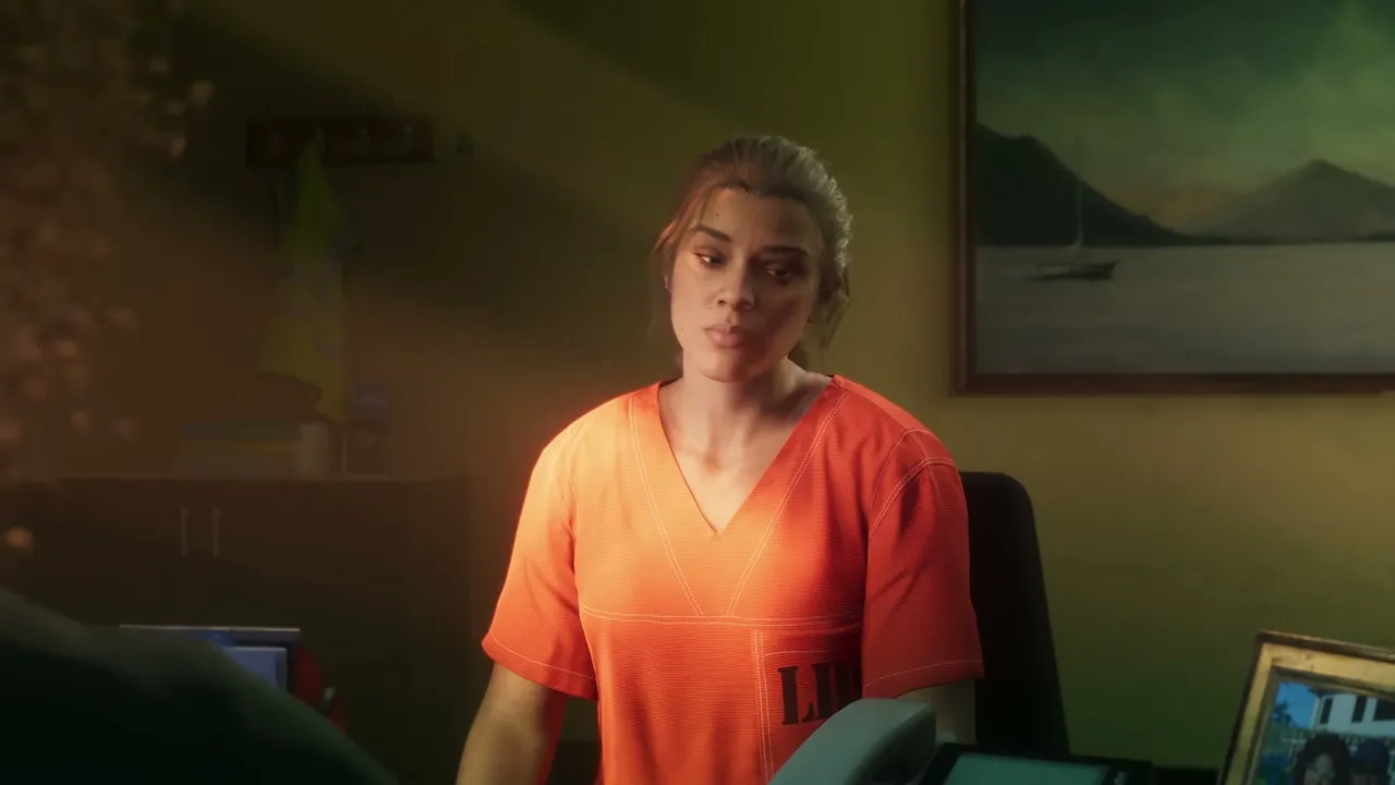 Lucia Caminos, wearing an orange prison jumpsuit, sits at a desk in an office with a painting of a…