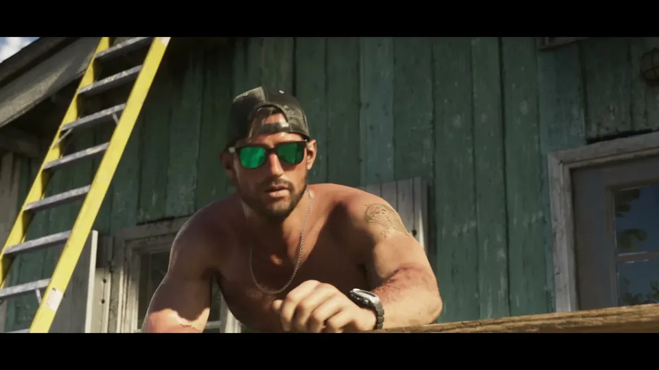 A shirtless Jason Duval, wearing a baseball cap and green mirrored sunglasses, leans on a wooden railing in front of a weathered green wooden building with a yellow ladder.