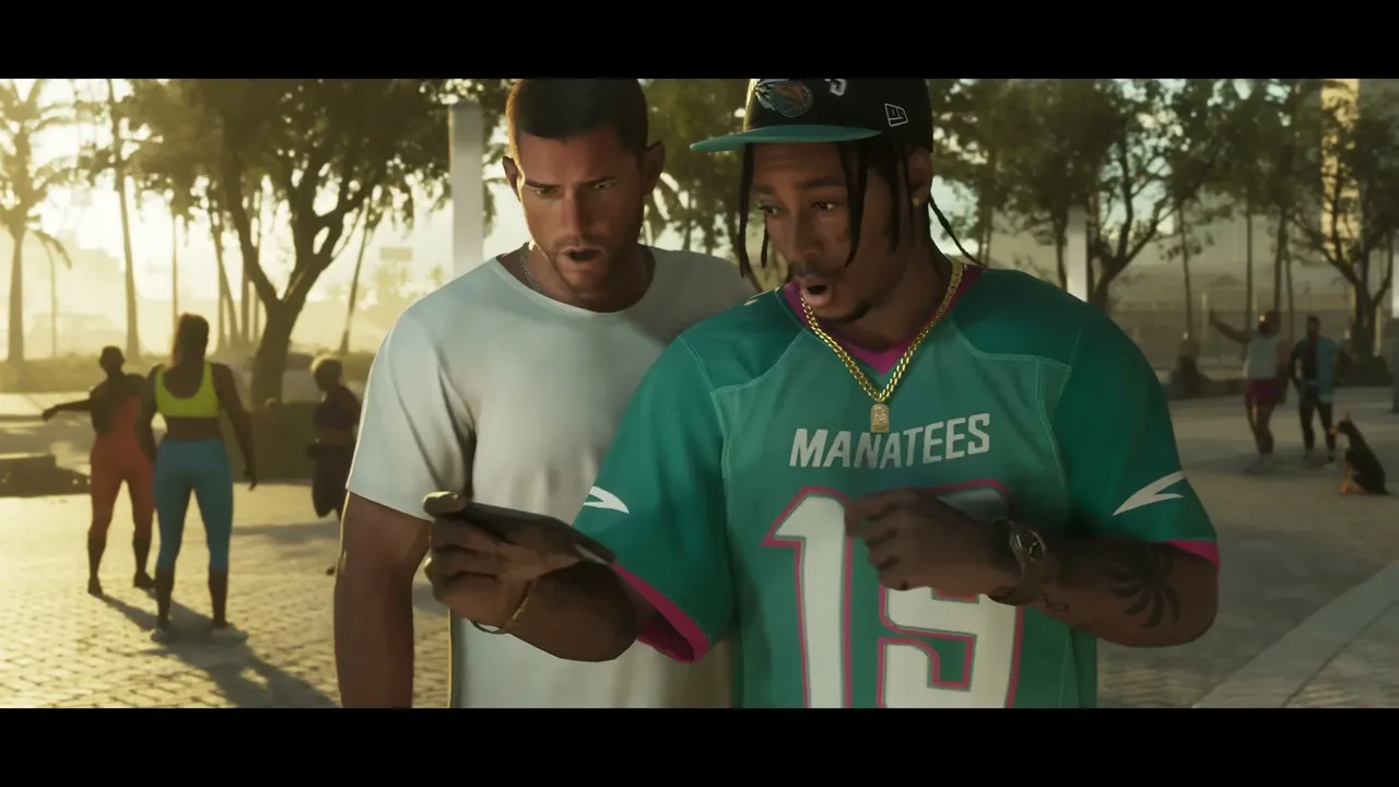 Two men, one in a white t-shirt and the other in a teal 'MANATEES' jersey, are looking intently at…